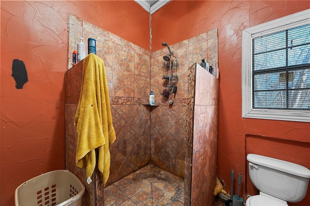 bathroom with a tile shower and crown molding