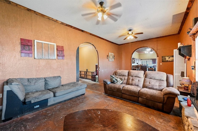 living room with a textured ceiling, ceiling fan, and ornamental molding