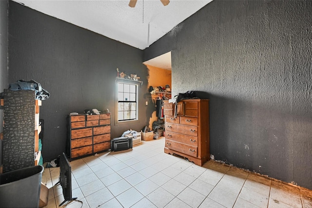 tiled bedroom featuring ceiling fan and a textured ceiling