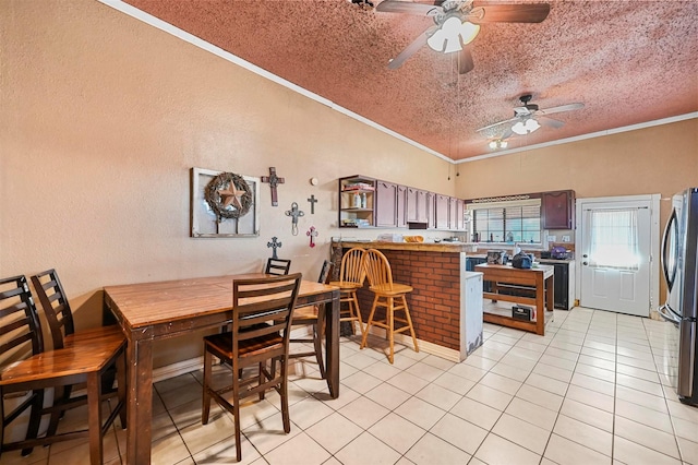 tiled dining area with ceiling fan, a textured ceiling, and ornamental molding