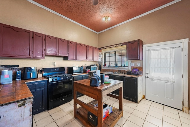 kitchen featuring black gas range, sink, crown molding, a textured ceiling, and light tile patterned flooring