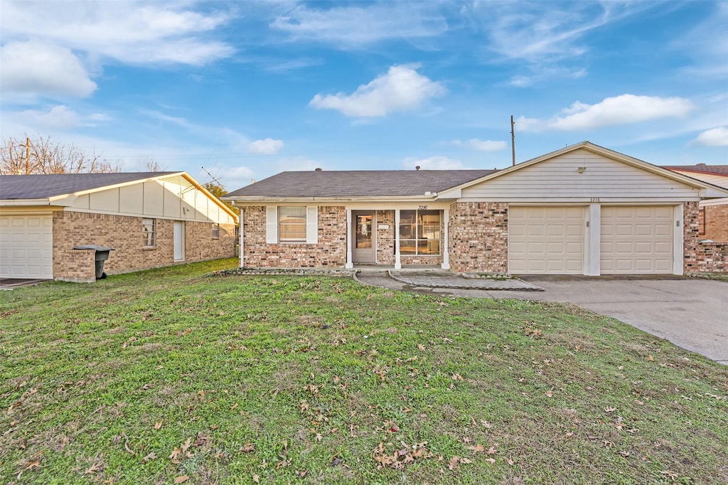 single story home featuring a front lawn and a garage