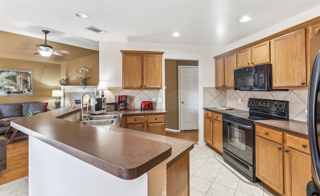 kitchen with sink, light tile patterned flooring, ceiling fan, backsplash, and black appliances