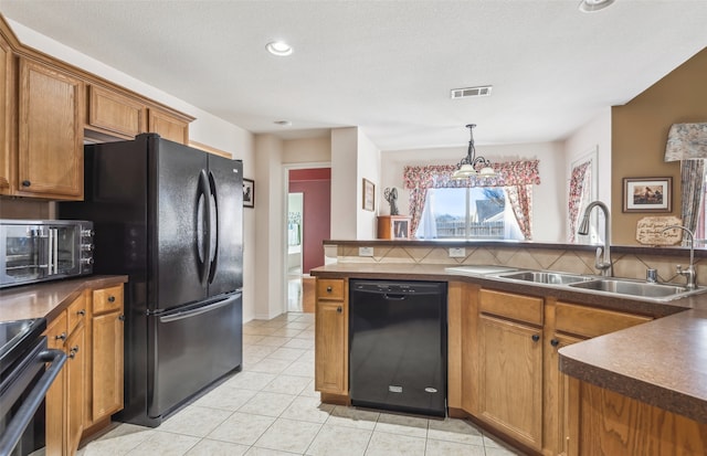 kitchen with sink, decorative backsplash, black appliances, and hanging light fixtures