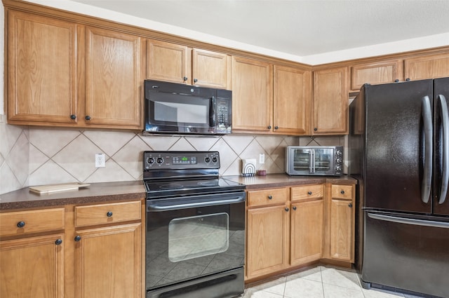 kitchen with light tile patterned floors, decorative backsplash, and black appliances