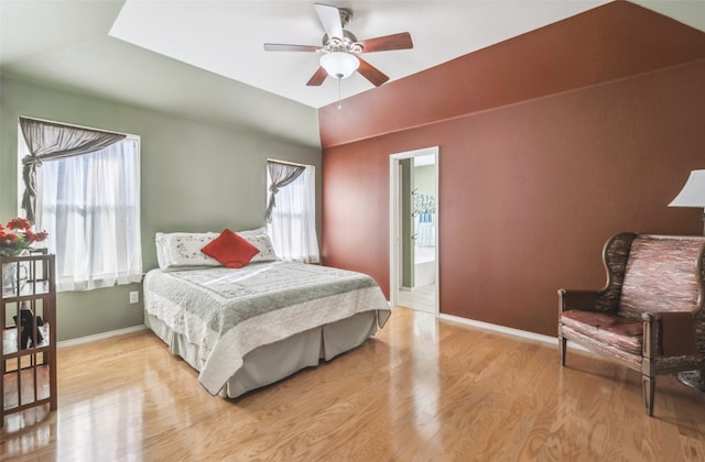 bedroom featuring ceiling fan, light hardwood / wood-style flooring, and ensuite bath