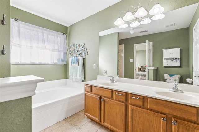 bathroom featuring tile patterned flooring, tiled bath, toilet, vanity, and a notable chandelier