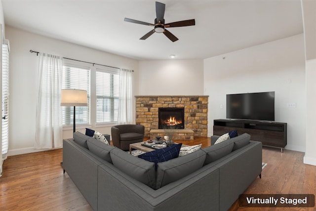 living room with ceiling fan, light hardwood / wood-style floors, and a fireplace