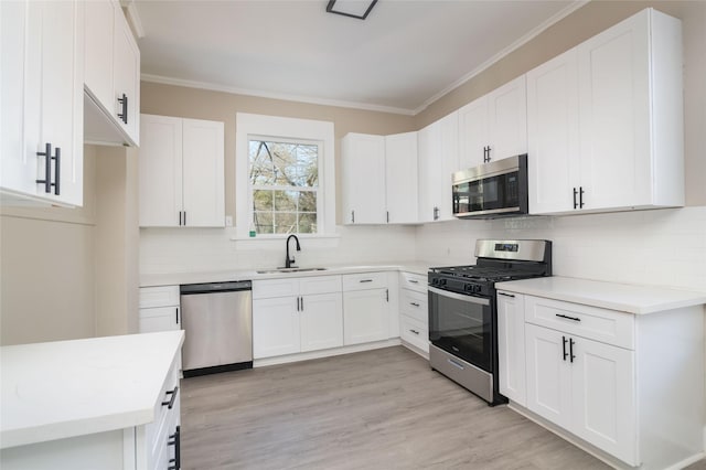 kitchen with light hardwood / wood-style flooring, stainless steel appliances, tasteful backsplash, white cabinets, and sink