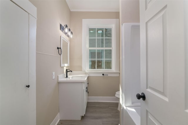 bathroom with wood-type flooring, ornamental molding, vanity, and toilet