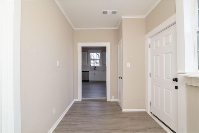 hallway with sink, light hardwood / wood-style flooring, and crown molding