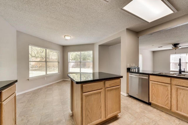 kitchen featuring sink, a kitchen island, a healthy amount of sunlight, and dishwasher