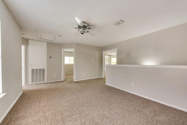 unfurnished room with ceiling fan, carpet floors, and a textured ceiling