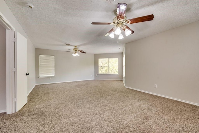 spare room featuring a textured ceiling, ceiling fan, and carpet