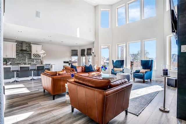 living area with recessed lighting, visible vents, baseboards, and light wood finished floors