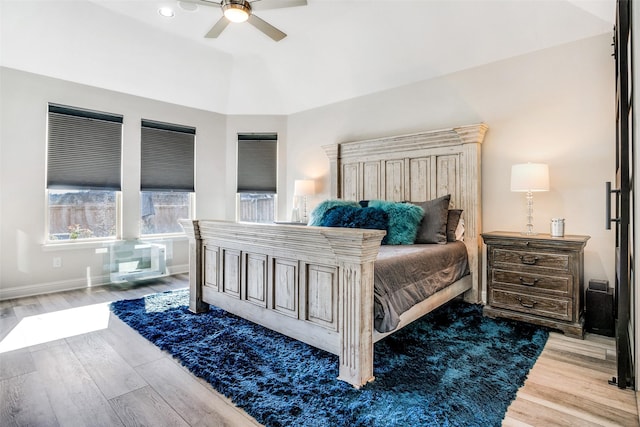 bedroom featuring ceiling fan, baseboards, wood finished floors, and vaulted ceiling