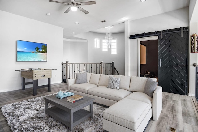 living room with baseboards, a barn door, and wood finished floors