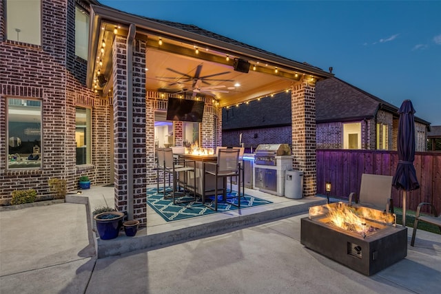 view of patio with a grill, a fire pit, ceiling fan, and fence