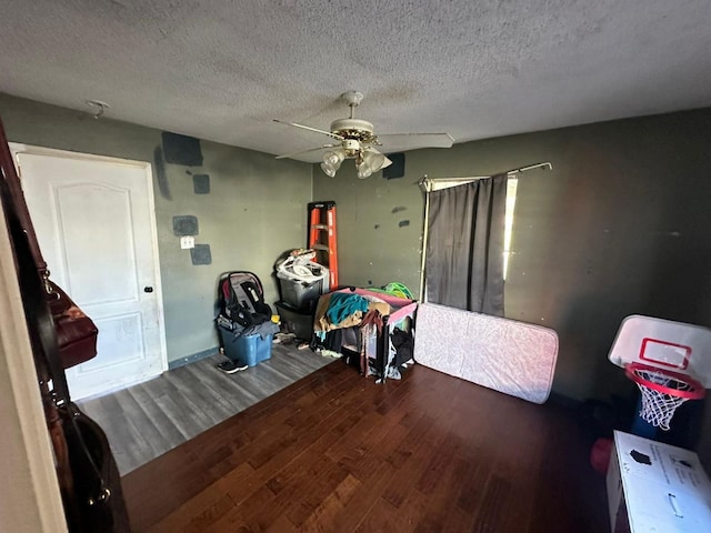 bedroom with a textured ceiling, ceiling fan, and wood-type flooring