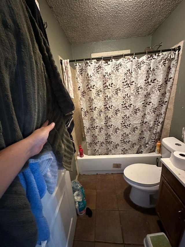 full bathroom featuring toilet, a textured ceiling, shower / bath combination with curtain, tile patterned floors, and vanity