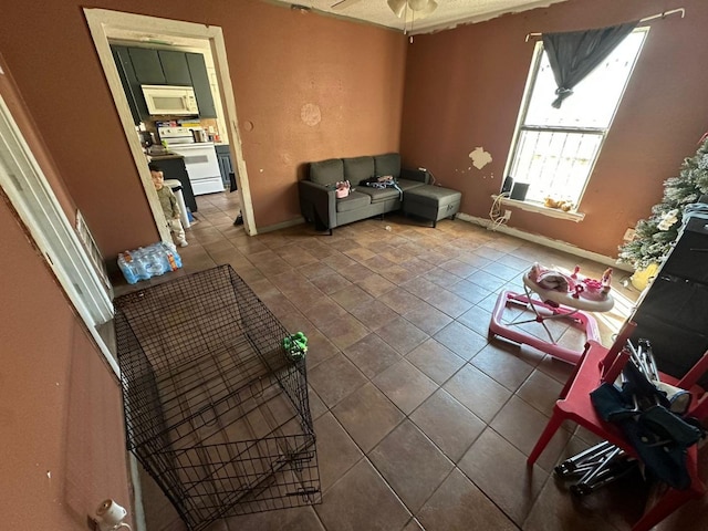 living room featuring tile patterned flooring and ceiling fan