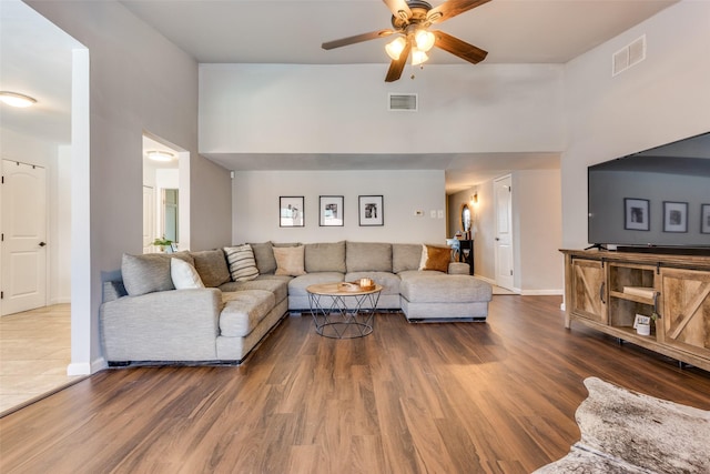 living room with ceiling fan and dark hardwood / wood-style flooring