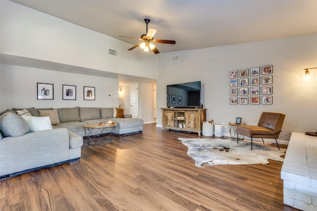 living room featuring ceiling fan, hardwood / wood-style floors, and lofted ceiling