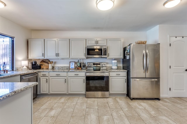 kitchen with stainless steel appliances and light stone countertops