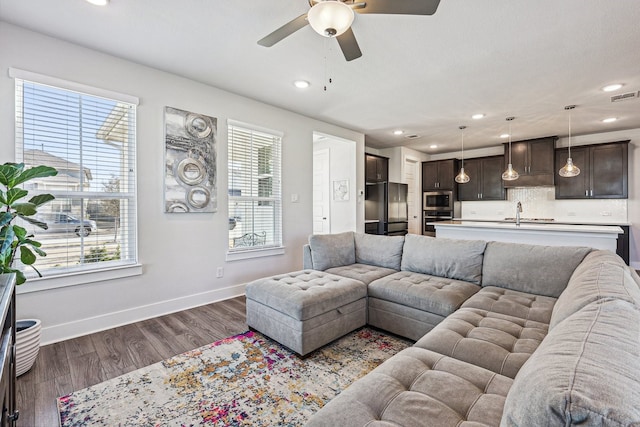 living room featuring ceiling fan, dark hardwood / wood-style flooring, and plenty of natural light