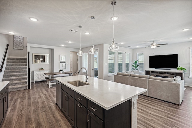 kitchen with wood-type flooring, an island with sink, ceiling fan, sink, and decorative light fixtures