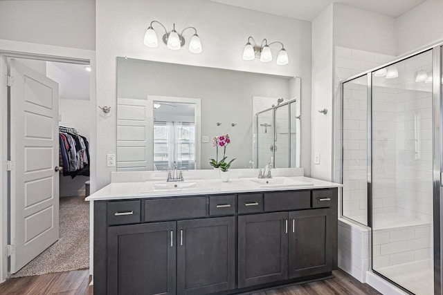 bathroom featuring walk in shower, vanity, and wood-type flooring