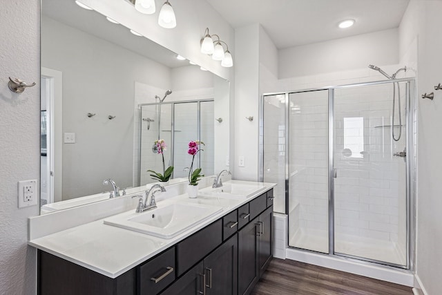 bathroom with an enclosed shower, vanity, and wood-type flooring