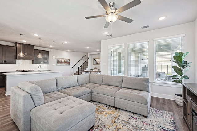 living room featuring sink, ceiling fan, a healthy amount of sunlight, and dark hardwood / wood-style floors