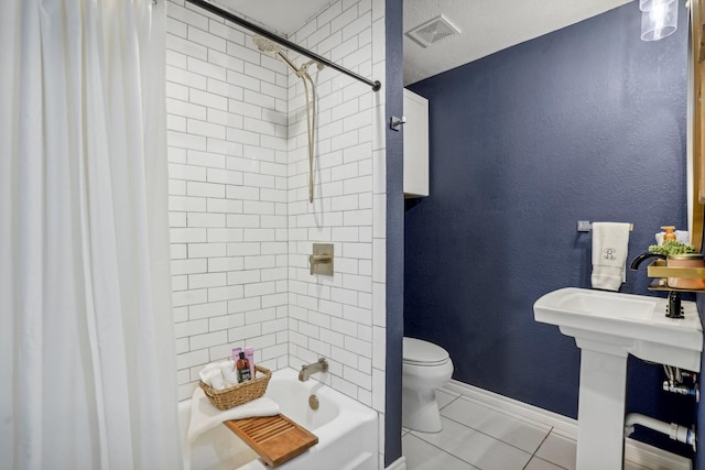 bathroom featuring tile patterned flooring, toilet, and shower / bath combo