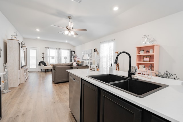 kitchen featuring vaulted ceiling, light wood-type flooring, ceiling fan, sink, and stainless steel dishwasher