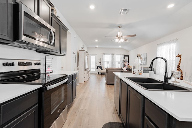 kitchen with light hardwood / wood-style flooring, stainless steel appliances, lofted ceiling, ceiling fan, and sink