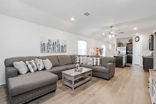 living room featuring ceiling fan and light wood-type flooring