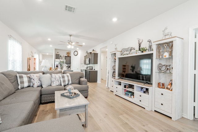 living room featuring ceiling fan and light hardwood / wood-style floors