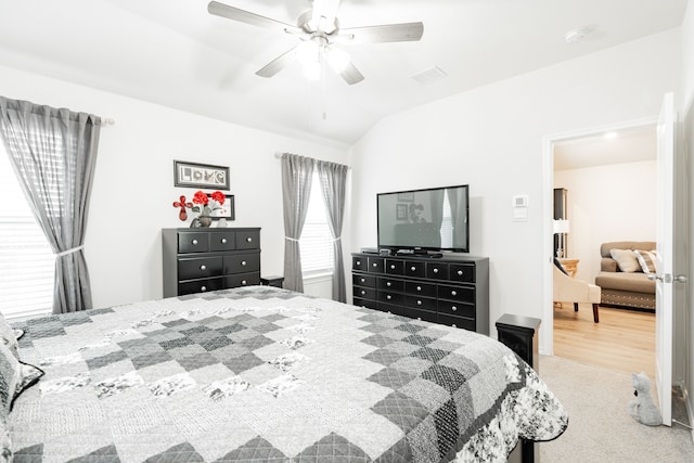 carpeted bedroom with ceiling fan and vaulted ceiling