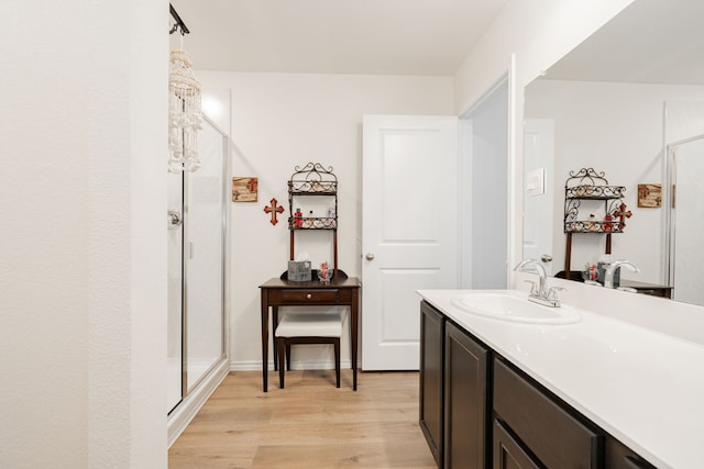 bathroom featuring hardwood / wood-style flooring, a shower with door, and vanity