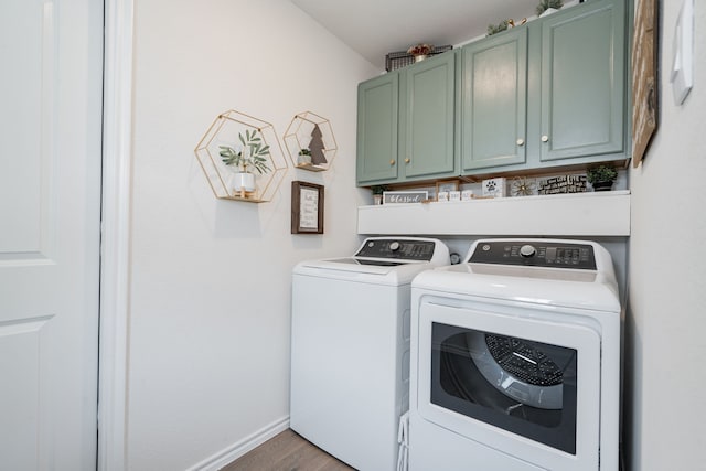 washroom featuring washer and dryer, cabinets, and hardwood / wood-style floors