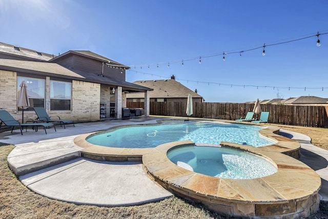 view of swimming pool with a patio and an in ground hot tub