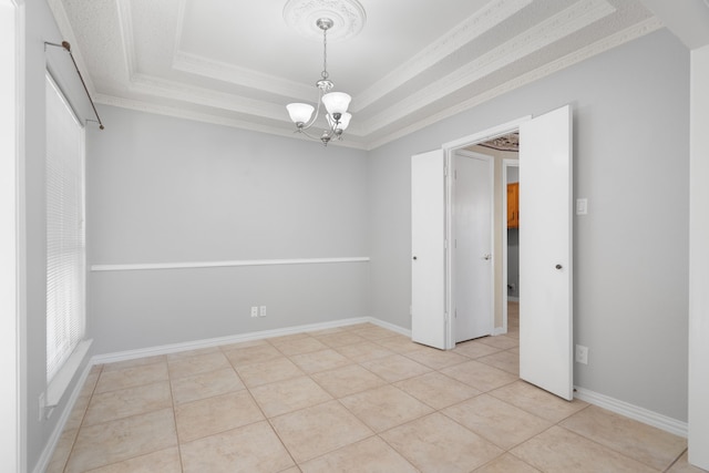 tiled empty room with a raised ceiling, crown molding, and a chandelier