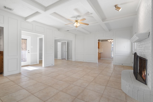 unfurnished living room featuring beam ceiling, light tile patterned flooring, and coffered ceiling