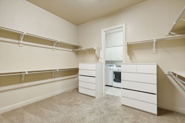 spacious closet with separate washer and dryer and light colored carpet