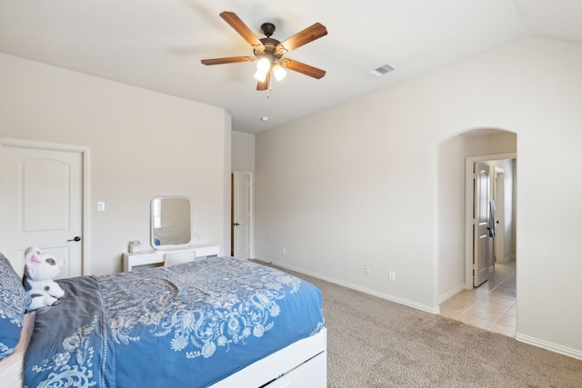 bedroom with ceiling fan, light colored carpet, and vaulted ceiling