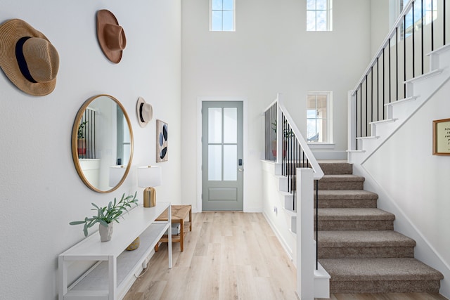 foyer featuring a towering ceiling and light wood-type flooring