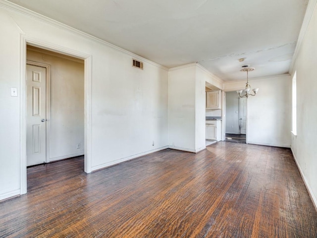 unfurnished living room featuring dark hardwood / wood-style flooring, crown molding, and a notable chandelier