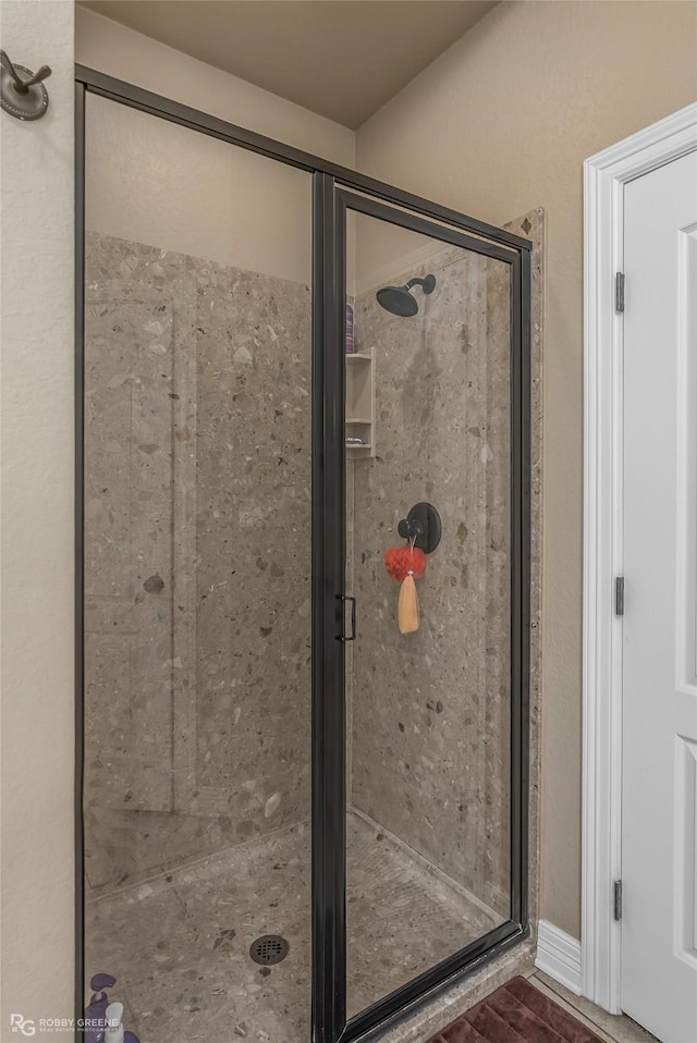 bathroom with a shower with door