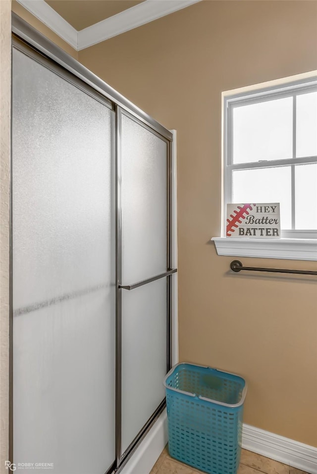 bathroom with an enclosed shower, tile patterned flooring, and ornamental molding